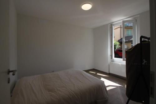 1 dormitorio con cama y ventana en Magnifique et spacieux appartement à Lausanne, en Lausana