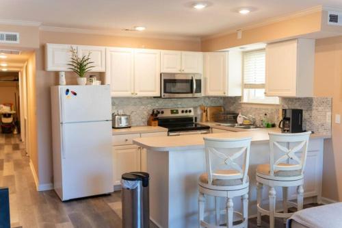 a kitchen with a white refrigerator and two bar stools at North Ocean city newly Remodeled in Ocean City