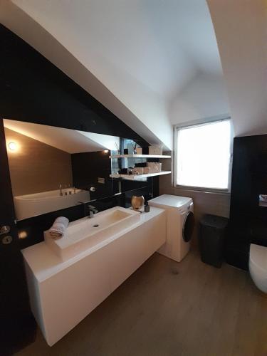 a bathroom with a tub and a sink and a toilet at Luxury Apartment Mare in Brodarica