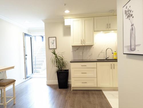 a kitchen with white cabinets and a sink at Nice home away at Vancouver near YVR in Vancouver