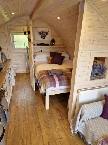 um quarto com 2 camas num chalé de madeira em Tighlochan pods em Scourie