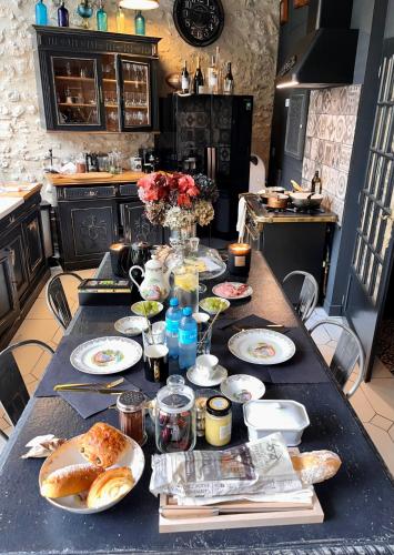 a table with plates of food on it in a kitchen at Le 215 Gambetta boutique hôtel en Provence in Cavaillon