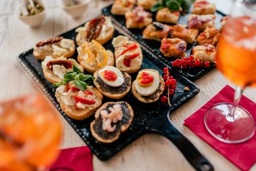 a plate of appetizers on a table with a drink at Fracanzana Hotel in Montebello Vicentino