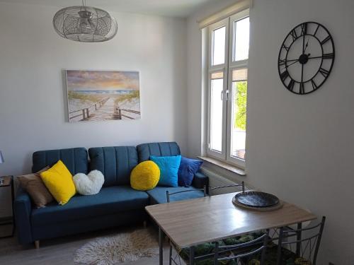 a living room with a blue couch and a table at Apartament Meluzyna in Puck