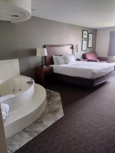 a hotel room with a bed and a bath tub at AmericInn by Wyndham Red Wing in Red Wing