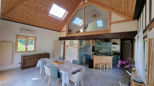 une cuisine et une salle à manger avec une table et des chaises dans l'établissement Gîte Du Grestain / Spa, à Toutainville