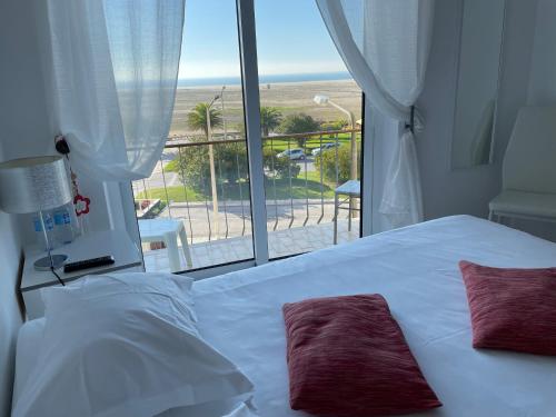 a bedroom with a bed and a view of the ocean at Stella di Mare - Alojamento Local in Figueira da Foz