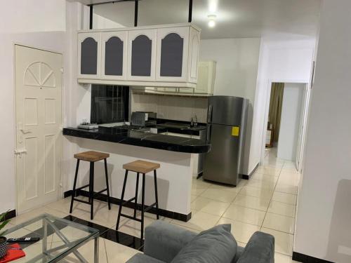a living room with a couch and a kitchen at Comfortable 3-Bedroom Apartment, close to the American Consulate in Guayaquil