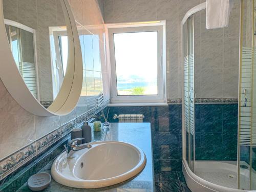 een badkamer met een wastafel, een bad en een spiegel bij Miracaminha in Caminha