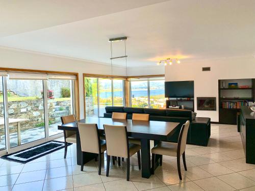 a dining room and living room with a table and chairs at Trajadinha - Miracaminha in Caminha