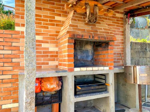 an outdoor brick oven in a brick wall at Trajadinha - Miracaminha in Caminha