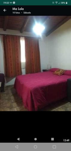 1 dormitorio con 1 cama con manta roja en Cabaña El Tala-Tanti in 