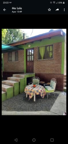 una mesa y sillas frente a una casa en Cabaña El Tala-Tanti in 
