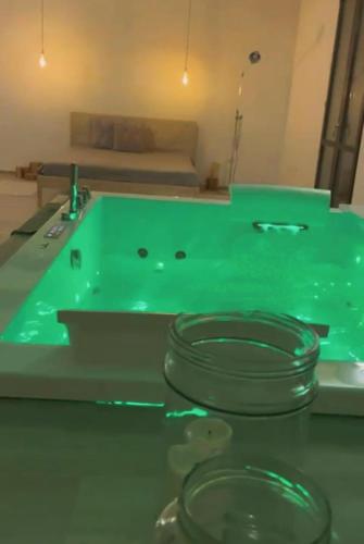 a green bath tub in a room with a sink at MASSERIA INCANTAMENTO Suite Bouganville in Latiano
