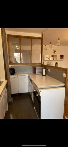 une cuisine avec des comptoirs et des placards blancs dans l'établissement T3 collines niçoises au calme avec stationnement privatif, à Nice