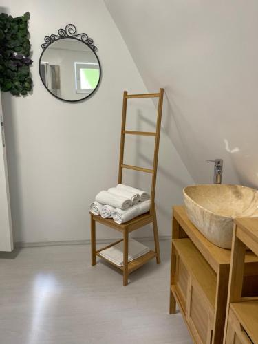 uma casa de banho com um lavatório, uma cadeira e um espelho. em Cabane A-Frame Svinița em Sviniţa