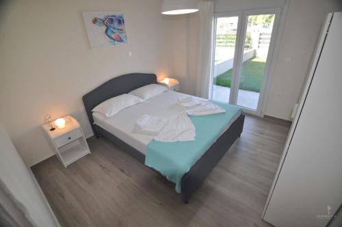 a small bedroom with a bed and a night stand at Zennova #24, FLOW Nikiti Family Apt in Nikiti