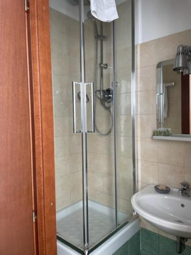 a shower with a glass door next to a sink at casa san Pietro in Rome