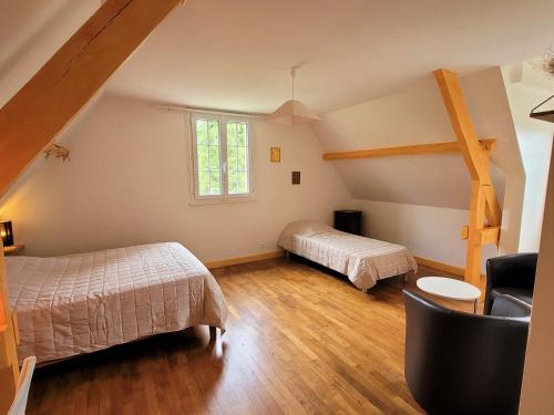 1 dormitorio en el ático con 2 camas y ventana en L'Oasienne, en Lissac et Mouret