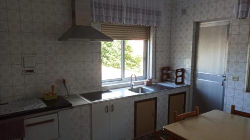 cocina con fregadero y ventana en Casa Vista Alegre en Oia, en Oia