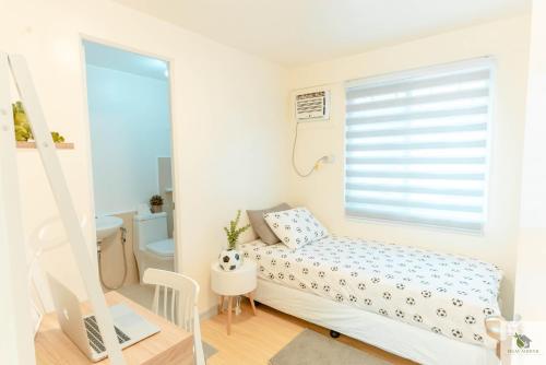 a small bedroom with a bed and a window at DGM AirBnB Urdaneta Pangasinan in Bayaoas