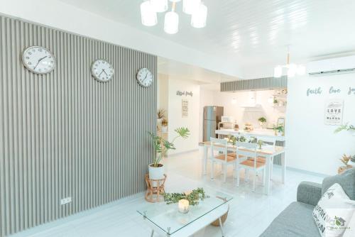 a living room with clocks on the wall and a table at DGM AirBnB Urdaneta Pangasinan in Bayaoas
