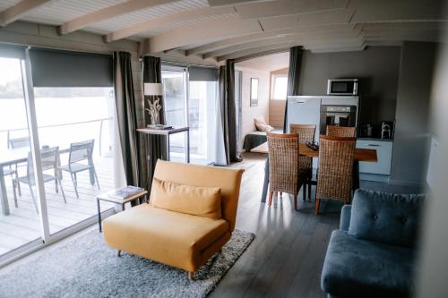 un soggiorno con divano e tavolo con sedie di Comme un Poisson dans l'Eau a Villennes-sur-Seine