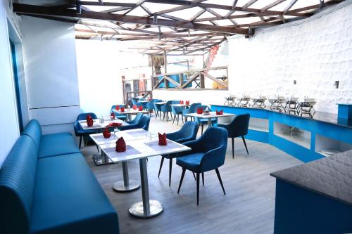 a restaurant with blue booths and tables and chairs at Comfort Inn Silver Arch Hotel, Mussoorie in Mussoorie