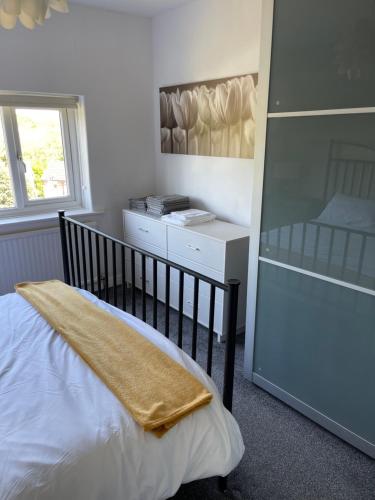 een slaapkamer met een wieg en een deken erop bij Lovely 3 bedroom house in Romiley, Stockport with parking for 3 cars in Romiley