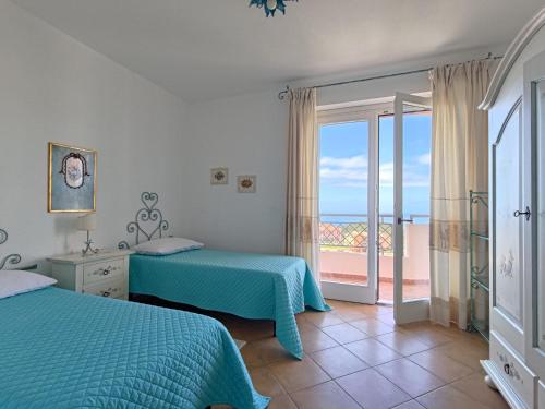 a bedroom with two beds and a view of the ocean at Splendida vista sul mare in Nebida