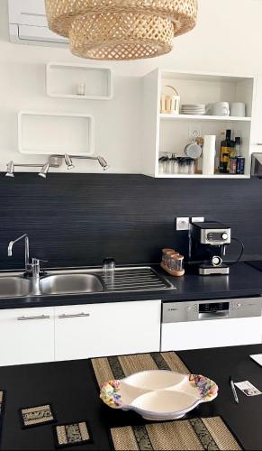 a kitchen with white cabinets and a sink at Rare ***Centre ville * Parking in Montpellier