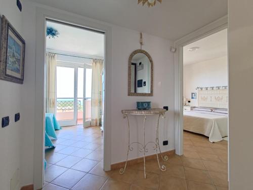 a hallway with a bedroom with a bed and a mirror at Splendida vista sul mare in Nebida