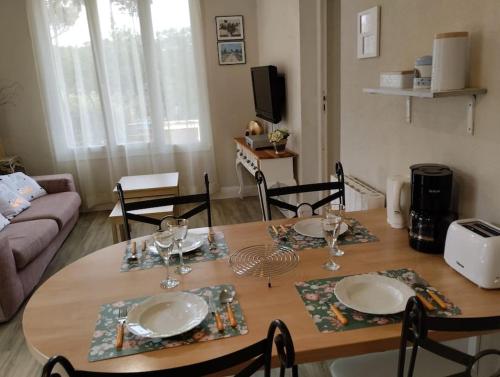 una mesa de comedor con platos y vasos. en jolie Mazet avec piscine privée !, en Nimes