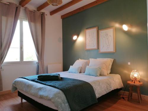 a bedroom with a bed with a green wall at Maison de campagne avec jacuzzi 