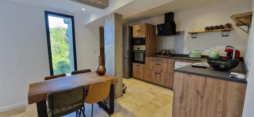 a kitchen with a wooden table and a large window at A Pasturella, Jacuzzi Spa in Venzolasca