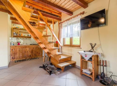 a living room with a wooden staircase in a house at Domek Bogdanka in Polańczyk