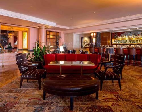 a hotel lobby with a red couch and a bar at Condado Vanderbilt Hotel in San Juan