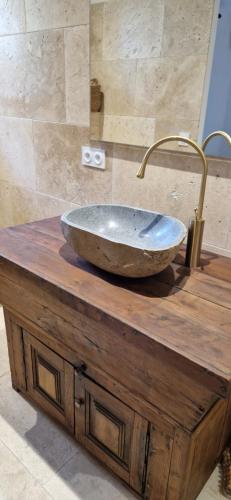 a bathroom with a stone sink on a wooden table at A Pasturella, Jacuzzi Spa in Venzolasca