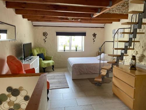 a bedroom with a bed and a spiral staircase at Le Potiron in Scheidgen