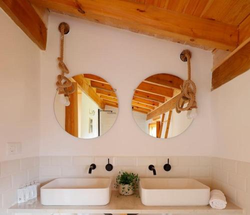 2 lavabos en un baño con 2 espejos en 201A La Huerta de Cayao, en Villaviciosa