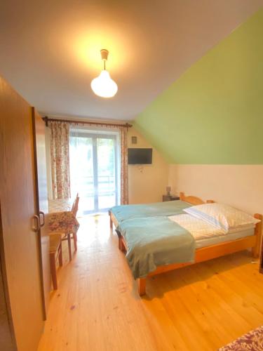 1 dormitorio con cama y ventana grande en Anna Pokoje Gościnne, en Krościenko nad Dunajcem