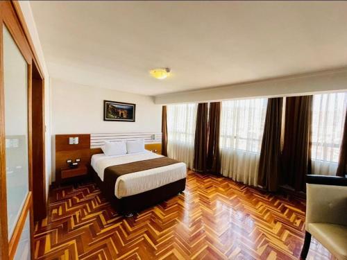 um quarto de hotel com uma cama num quarto em HOTEL POLO CUSCO SUITES em Cusco
