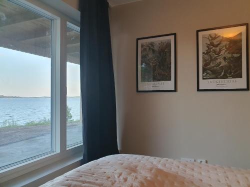 een slaapkamer met twee foto's aan de muur en een raam bij Villa Kolmården in Kolmården