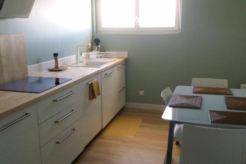 a kitchen with a sink and a table at Logement privée in La Teste-de-Buch