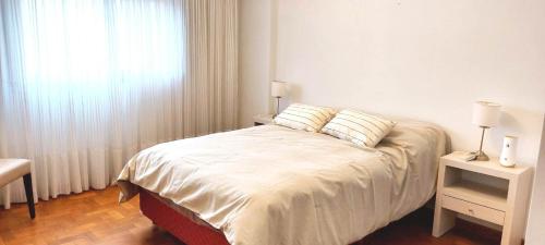 a bedroom with a large bed with a window at Departamento Plaza in Bahía Blanca