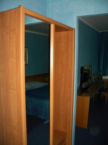 ajar door of a bedroom with a bed and a television at Kardamon in Żary