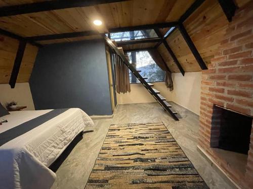 a bedroom with a bed and a fireplace at Portocielo Cabin in La Marquesa