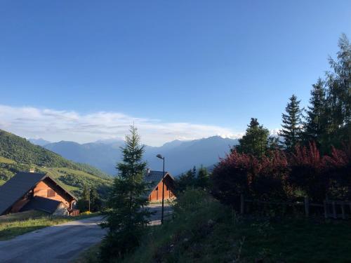 une maison sur une route avec des montagnes en arrière-plan dans l'établissement Appartement avec terrasse magnifique vue montagne, à Saint-François-Longchamp