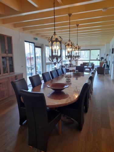 a dining room with a large wooden table and chairs at Vakantie Accommodatie Egelantier in Dwingeloo