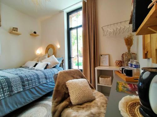 a bedroom with a bed and a chair and a window at LA CLOSERIE DE NOINTOT in Nointot